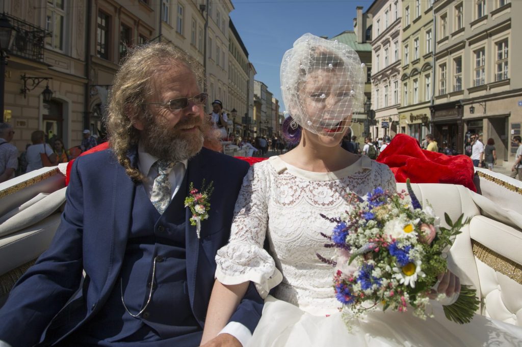 Rachael in her wedding dress beside her dad in a horse-drawn carriage on her wedding day